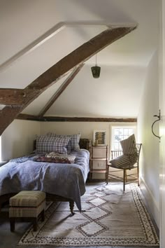 an attic bedroom with a bed and chair