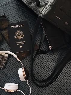 a passport, headphones and other items are on the floor next to a purse