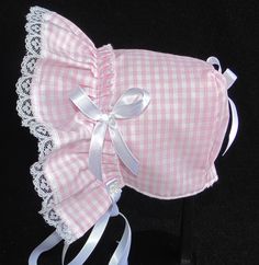 a pink and white checkered dog bed with ruffles