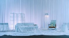 a room with white drapes and furniture on the floor in front of a curtained wall