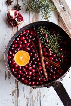 a pan filled with cranberries and cinnamons on top of a wooden table