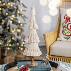 a small christmas tree sitting on top of a table next to a toy deer and book