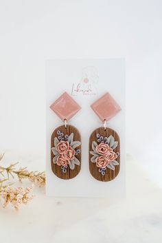 the wooden earrings with pink flowers are on display