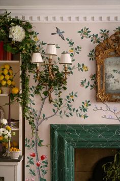 a living room filled with furniture and a fire place next to a wall covered in flowers