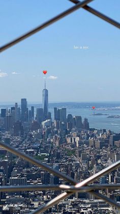 the city skyline is seen through a fence in this view from top of the empire building