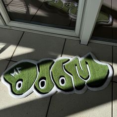 a green sticker that says boo on the side of a door with shoes in the background