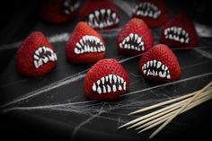 strawberries with white teeth and fangs on them are arranged in the shape of hearts