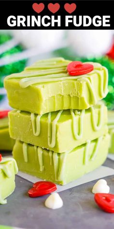 three pieces of green fudge sitting on top of each other in front of red and white candies