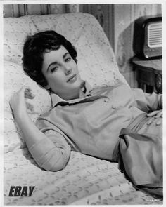 a black and white photo of a woman laying in bed