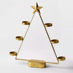 a gold christmas tree with candles in the shape of a star is shown against a white background