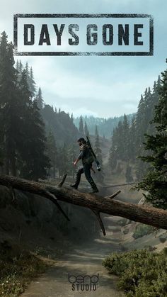 a man walking across a fallen tree over a forest