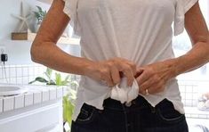 a woman standing in front of a bathroom sink holding her hands on her hips and looking at the camera