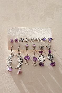 several pairs of dangling earrings are displayed on a piece of paper