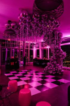 a room filled with lots of balloons and chandelier in the middle of it