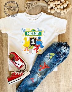 a white shirt with the name mason on it next to some shoes and a bag