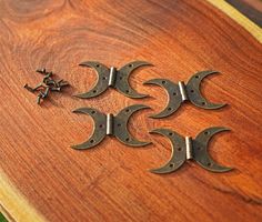 four pieces of metal sitting on top of a wooden table next to an arrow and star