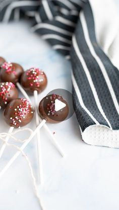 chocolate covered candies with sprinkles on a striped napkin and black and white tie