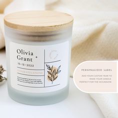 a jar of personalized candle next to a white towel and some dried lavenders