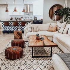 a living room filled with lots of furniture and decor on top of a wooden floor