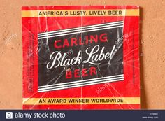 an old black label advertising beer on the wall in front of a brick wall with peeling paint