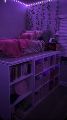 a bedroom with purple lights on the ceiling and bookshelves in front of it