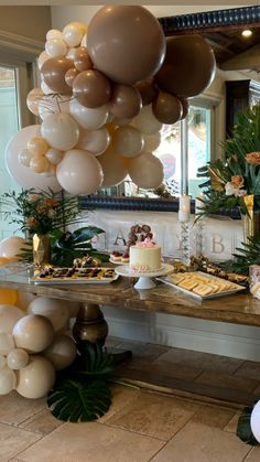 a table topped with lots of balloons and desserts