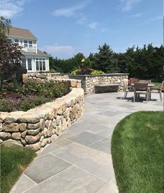 an outdoor patio with stone walls and seating area