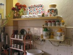 the kitchen is cluttered with pots, pans and utensils on shelves