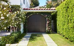 an entrance to a house surrounded by greenery