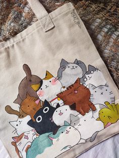 Hand Painted Tote bag 🐾 Cats Theme 🐱♥️ Size in Cm: 35*40*5 #handmade_With_RM_Store ✨🖤 #paint #painter #cat #meow #totebag #acrylic #acrylicpainting #love #smallbusiness #madeinegypt Acrylic Painting Ideas On Clothes, Cloth Bag Painting Ideas, Book Tote Bag Painting Ideas, Cute Tote Bags Paint, Cat Themed Crafts, Drawing On Bag, Bag Painting Ideas Diy, Tote Bag Ideas Paint, Drawing On Tote Bag