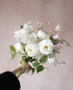 a woman holding a bouquet of white flowers