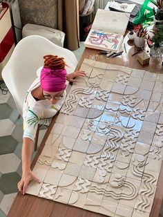 a woman is making decorative tiles on the floor