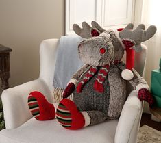 a stuffed moose sitting on top of a white chair