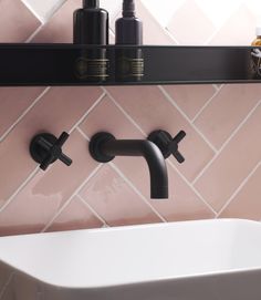 a white sink sitting under a mirror next to a black faucet