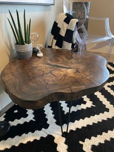 a wooden table sitting on top of a black and white rug