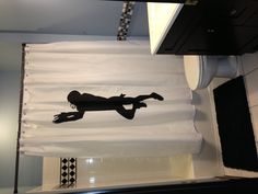 a bathroom with a shower curtain that has a silhouette of a person jumping in the air