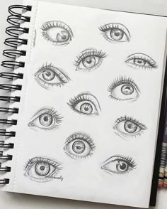 an open notebook with drawings of different eyes