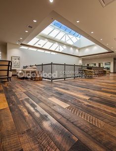 an empty room with wooden floors and skylights