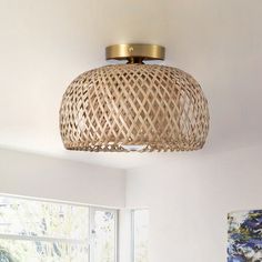 a living room with a large window and a rattan light fixture