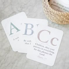 three cards with the letters abc and c on them sitting next to a basket full of books