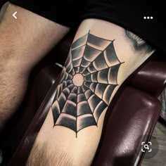 a man with a spider web tattoo on his leg