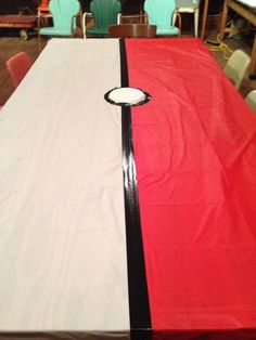 a table with red, white and black cloth on it in a room full of chairs