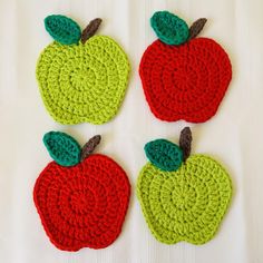 three crocheted apple coasters with green and red apples on them, one in the shape of an apple