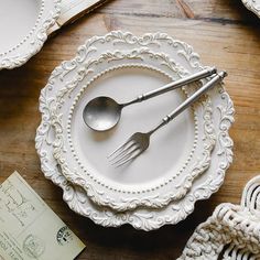 white plates and silverware on a wooden table