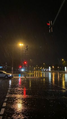 a car driving down a rain soaked street at night