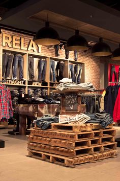 the inside of a clothing store with wooden pallets