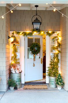 the front door is decorated for christmas with garland and lights