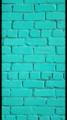 a blue brick wall that is painted bright turquoise