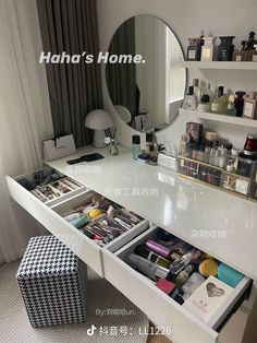 a white vanity with drawers underneath a mirror and a stool in front of the counter