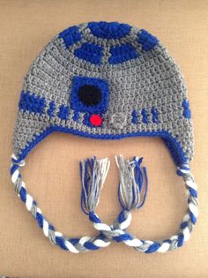 a crocheted hat with blue and white stripes on it, attached to a cord